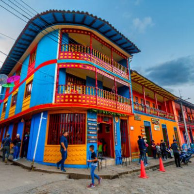 Raquira, Colombia - January 5, 2023: Tourists and local people walk the streets of the downtown area of the colorful town